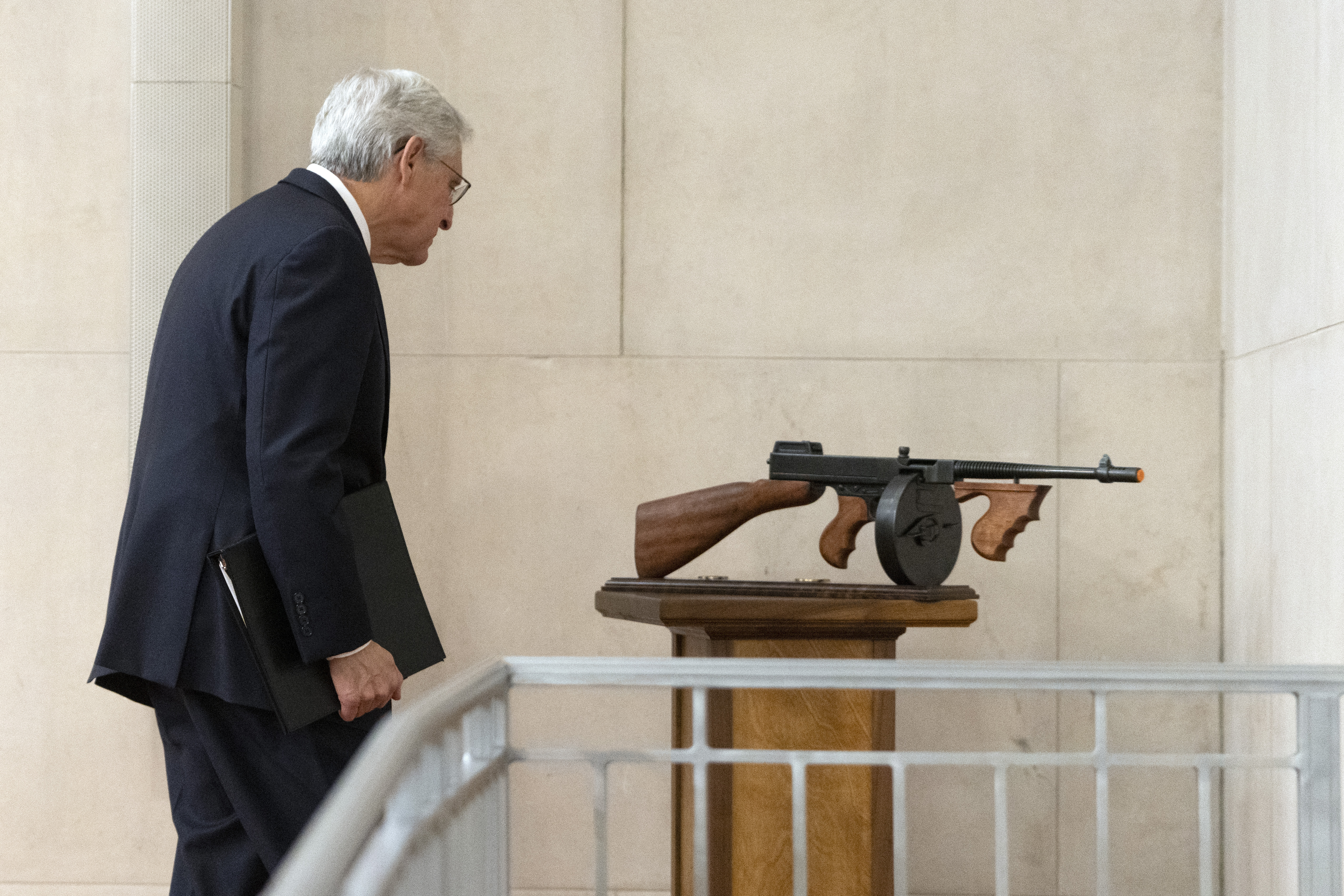 Attorney General Merrick Garland looks at a tommy gun given to him as a gift by FBI Director Christopher Wray after a farewell ceremony at the Department of Justice, Jan. 16, 2025, in Washington.